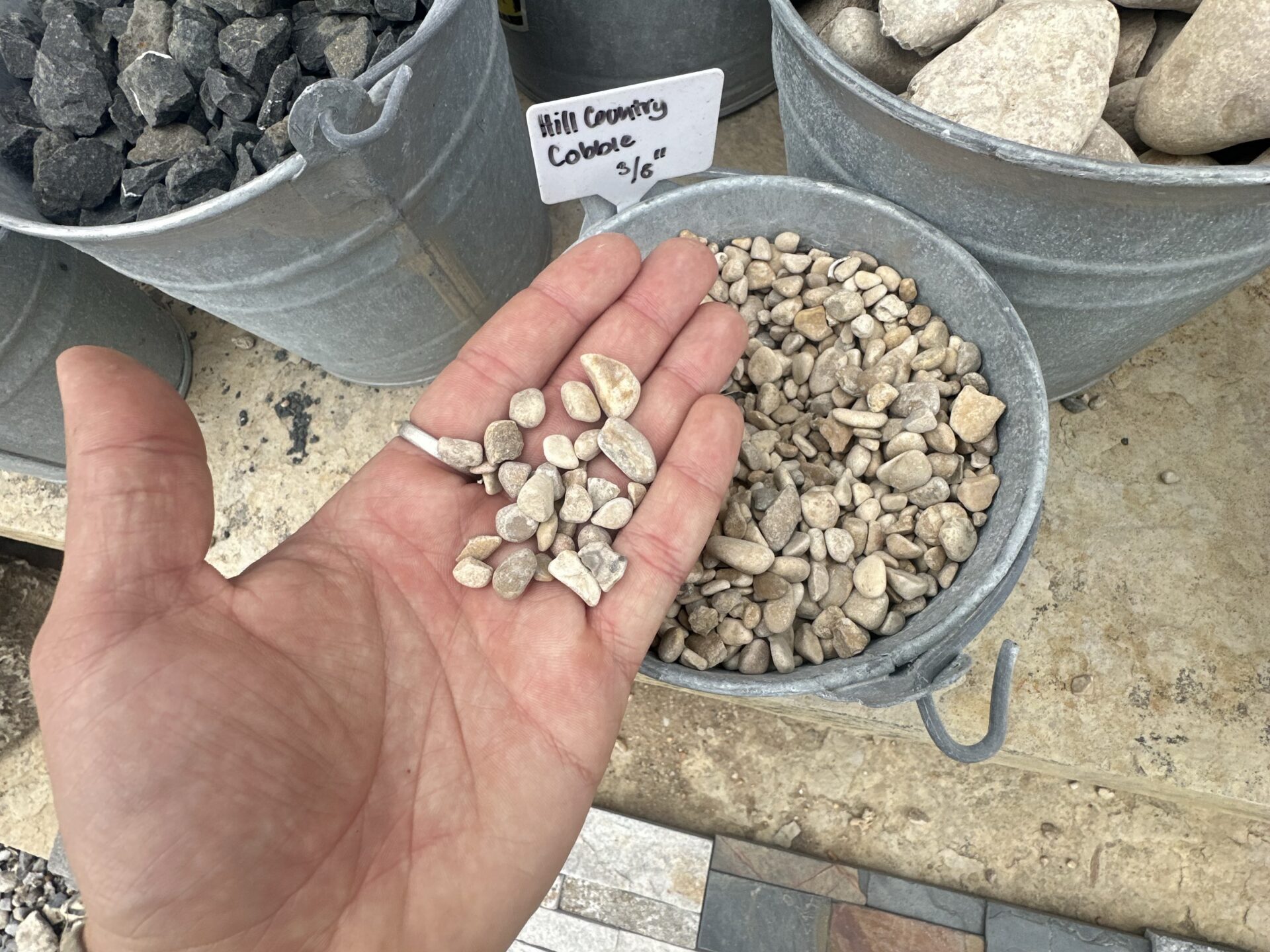 small tan river rock with hand comparison
